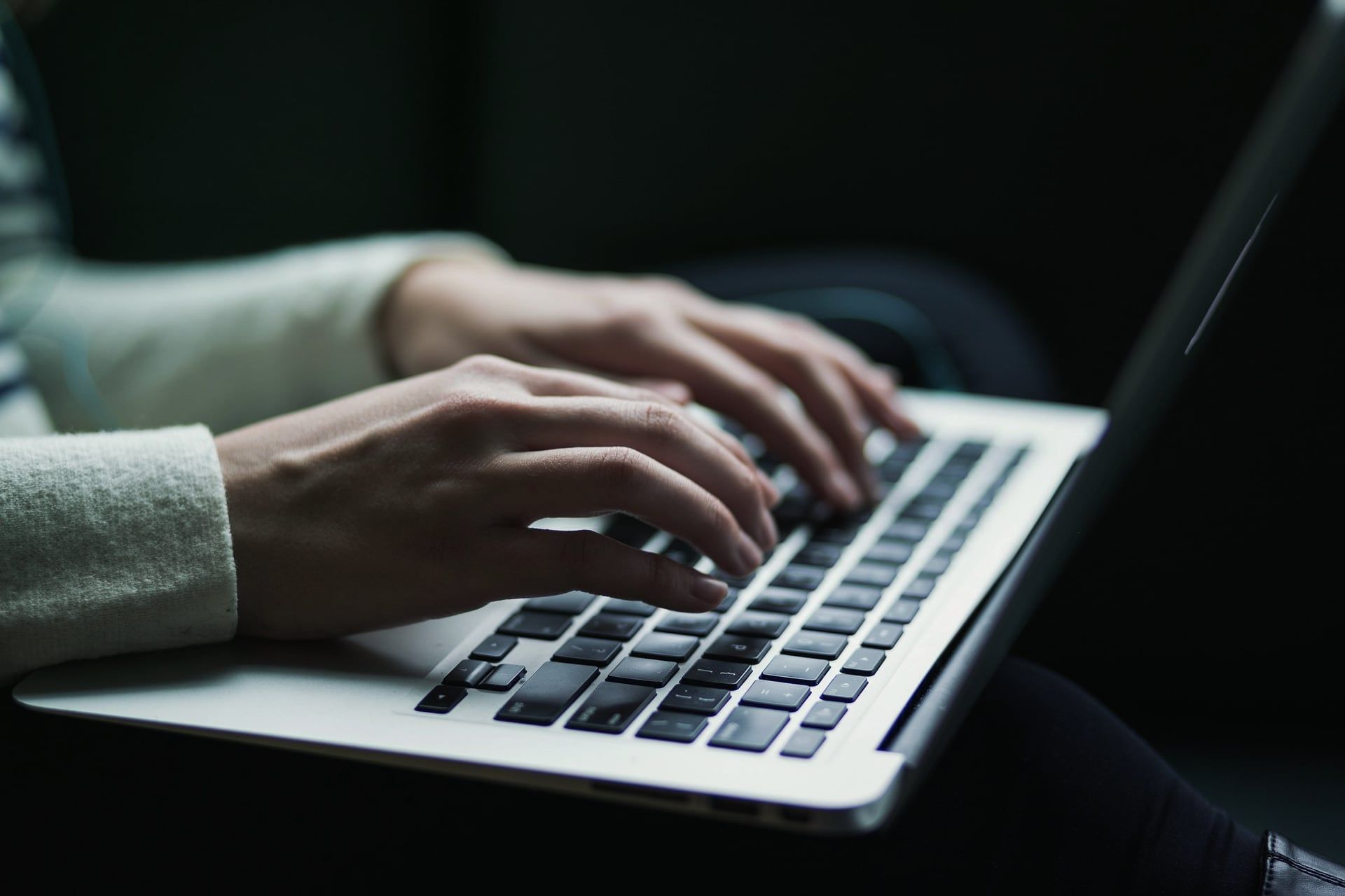 Mãos digitando no teclado de um notebook, como na digitação de um pedido de venda